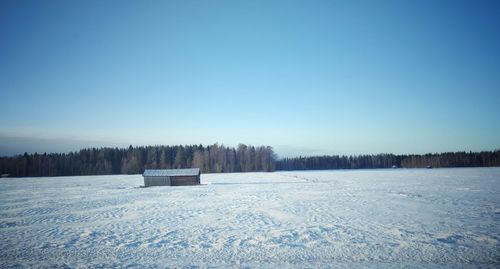 Scenic view of snow field against clear blue sky