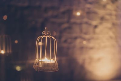 Close-up of illuminated tea light candle against wall