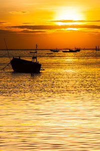 Silhouette of sailboat in sea against sky during sunset