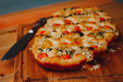 Close-up of food on table. homemade italian focaccia, with tomato, pink pepper and olive oil.