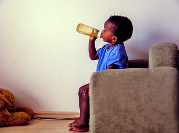 Portrait of toddler sitting on sofa at home