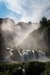 Scenic view of waterfall against sky