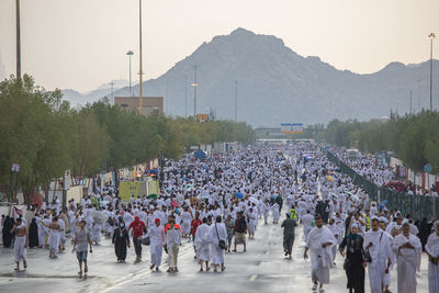 People walking on street in city against sky