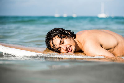 Portrait of shirtless young man in sea