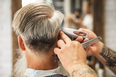 Hairdresser cutting hair of customer in salon