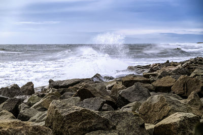 Scenic view of rocks in sea against sky