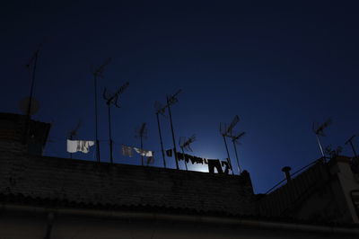 Low angle view of communications tower against sky at night