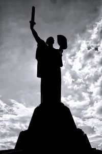 Low angle view of silhouette statue against sky