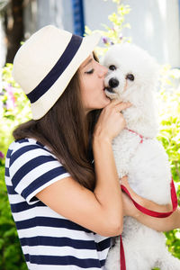 Midsection of woman with dog in hat