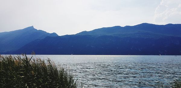 Scenic view of sea and mountains against sky