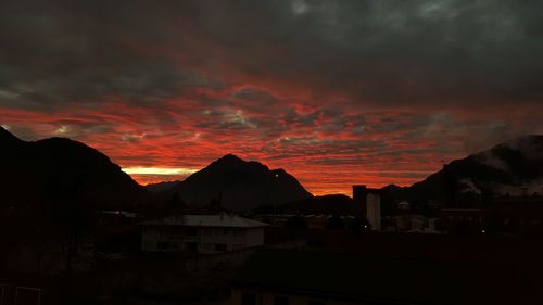 Scenic view of mountains against cloudy sky at sunset