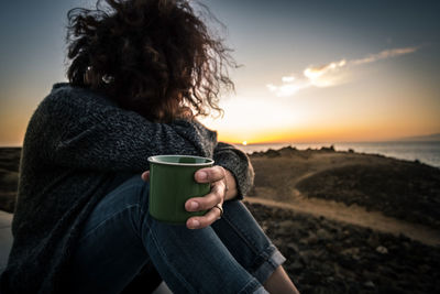 Woman looking at view and holding cup of coffee