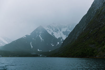 Scenic view of lake and snowcapped mountains against sky