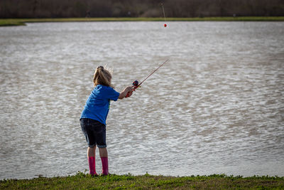 Rear view of girl playing in lake