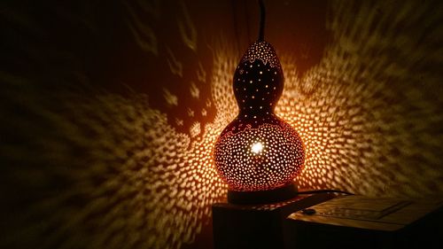 Low angle view of illuminated lighting equipment hanging on ceiling