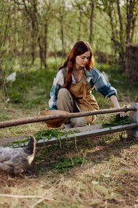 Young female farmer feeding chickens at farm