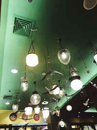 Low angle view of illuminated pendant lights hanging from ceiling