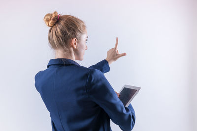 Low angle view of woman standing against white background