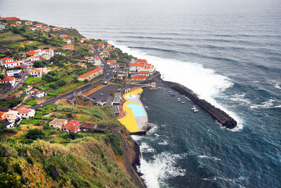 High angle view of residential buildings on mountain by sea