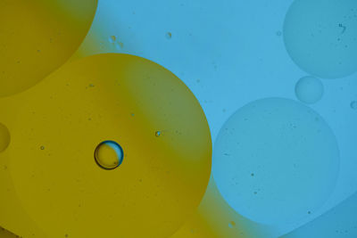 Top view oil bubbles drop on the water with colorful background, macro photography concept