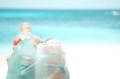 Close-up of water bottle on beach