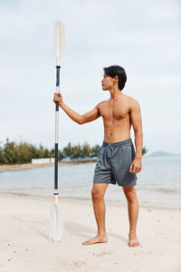 Rear view of man standing at beach