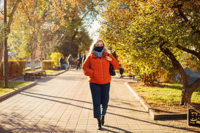 Full length of woman on footpath during autumn