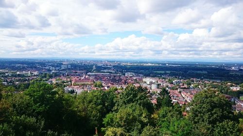 Aerial view of cityscape against cloudy sky