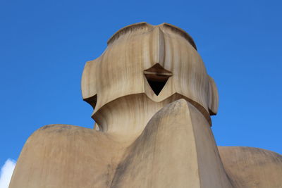 Low angle view of statue against blue sky