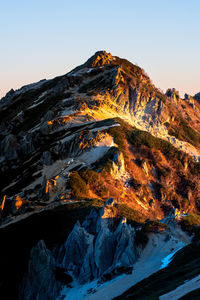 Snow capped mountain peak lighted by sunrise