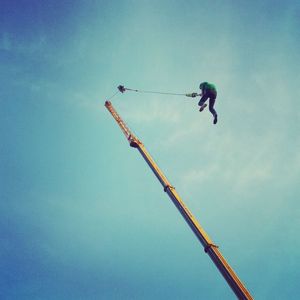 Low angle view of crane against sky