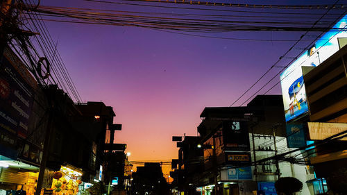 Low angle view of illuminated buildings against sky at sunset