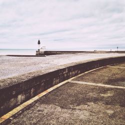 Footpath by sea against sky