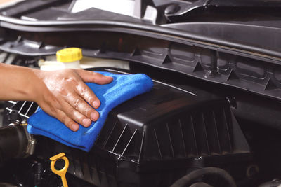 Cloth worker cleaning the car engine room