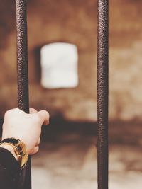 Close-up of hand holding metal window