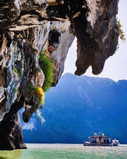 Rock formations by sea against mountain