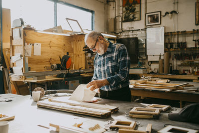 Craftsman examining documents at carpentry workshop