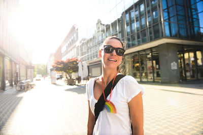 Portrait of young woman standing on street in city