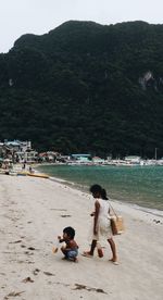 Rear view of mother and son on beach