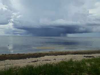 Scenic view of sea against storm clouds