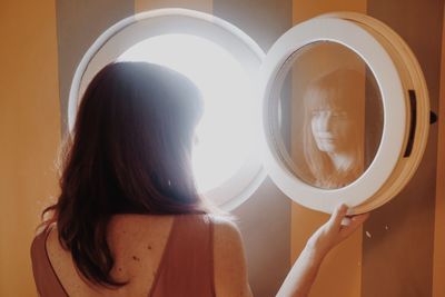 Rear view portrait of woman at home