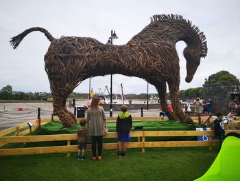 Rear view of people in park against sky