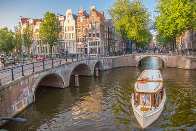 Arch bridge over canal in city against sky