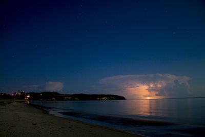 Scenic view of beach against sky at dusk