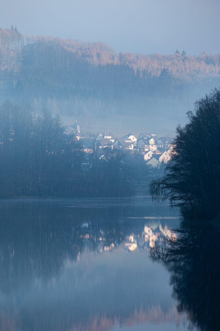reflection, water, morning, tree, scenics - nature, mist, lake, beauty in nature, winter, tranquility, nature, mountain, dawn, tranquil scene, plant, no people, sky, fog, snow, environment, cloud, cold temperature, landscape, forest, reservoir, land, non-urban scene, outdoors, day, idyllic, body of water, travel destinations, ice, sunrise