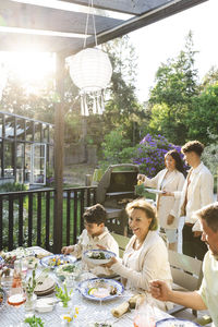 Family enjoying summer dinner party at back yard