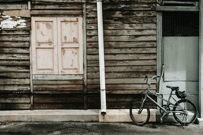 Bicycle parked against abandoned house