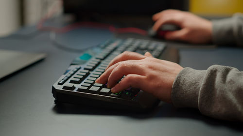 Close-up of man using laptop on table