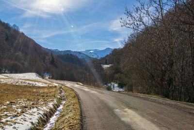 Road amidst snowcapped mountains against sky