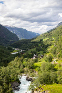 Scenic view of river amidst green landscape against sky